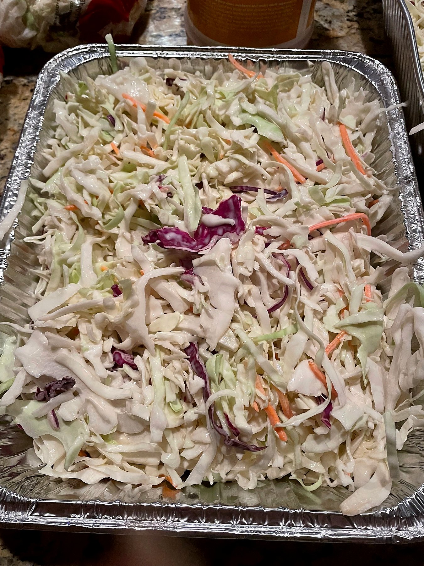 Creamy cabbage and carrot cole slaw served in a catering tray.